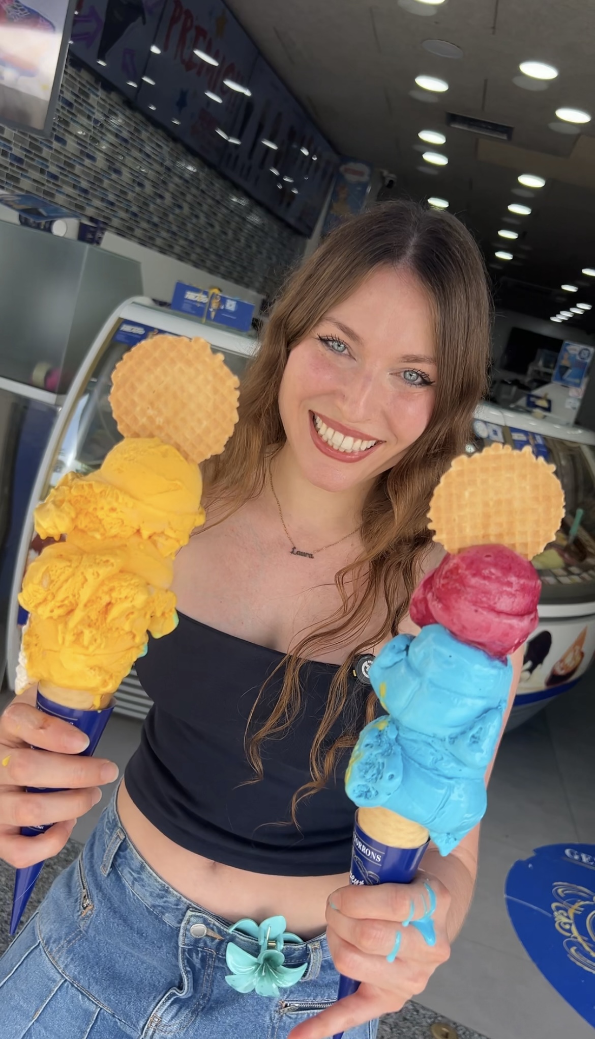 Laura sonriendo con dos helados de colores